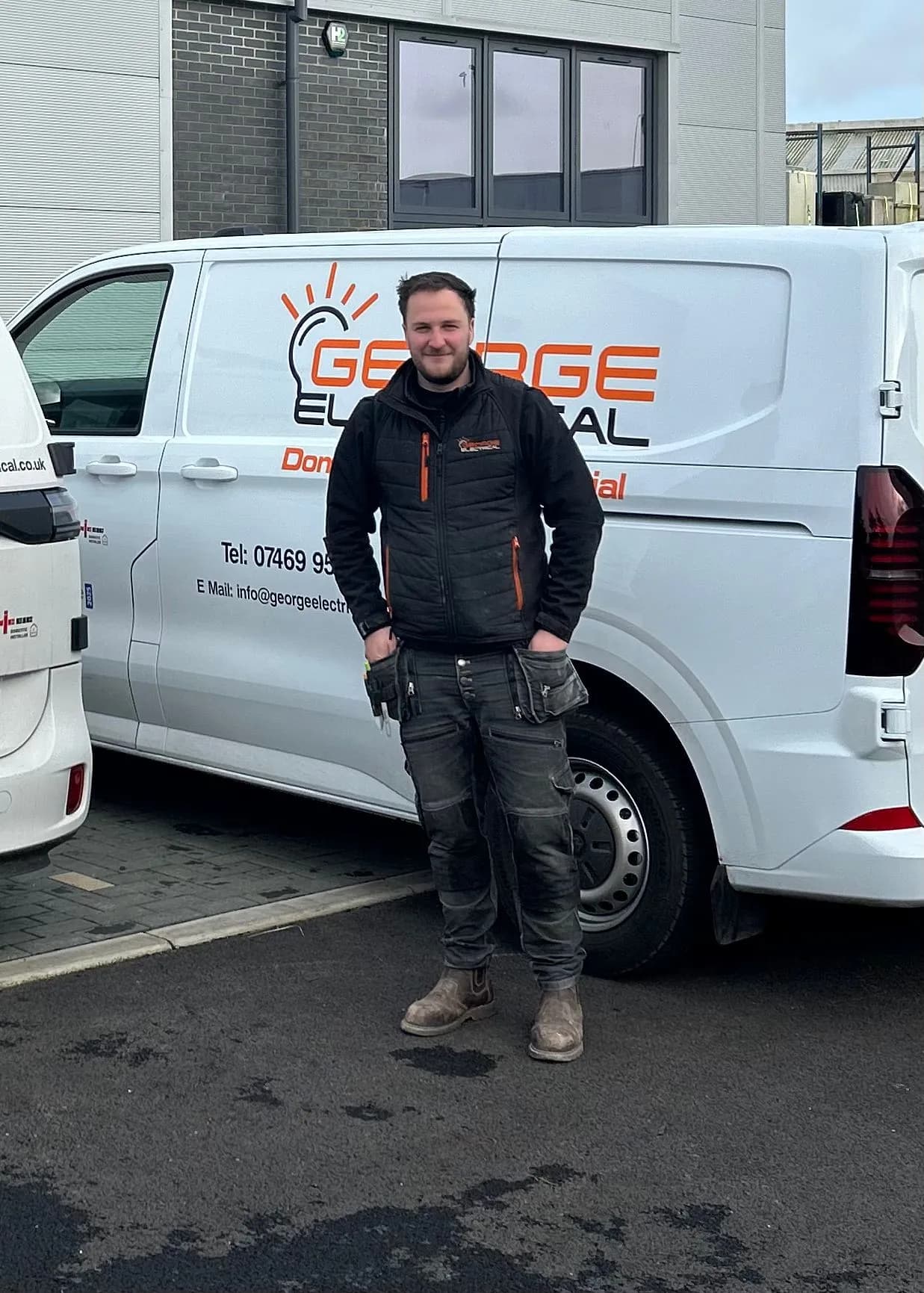 Luke George, Director of George Electrical, in front of a liveried George Electrical van